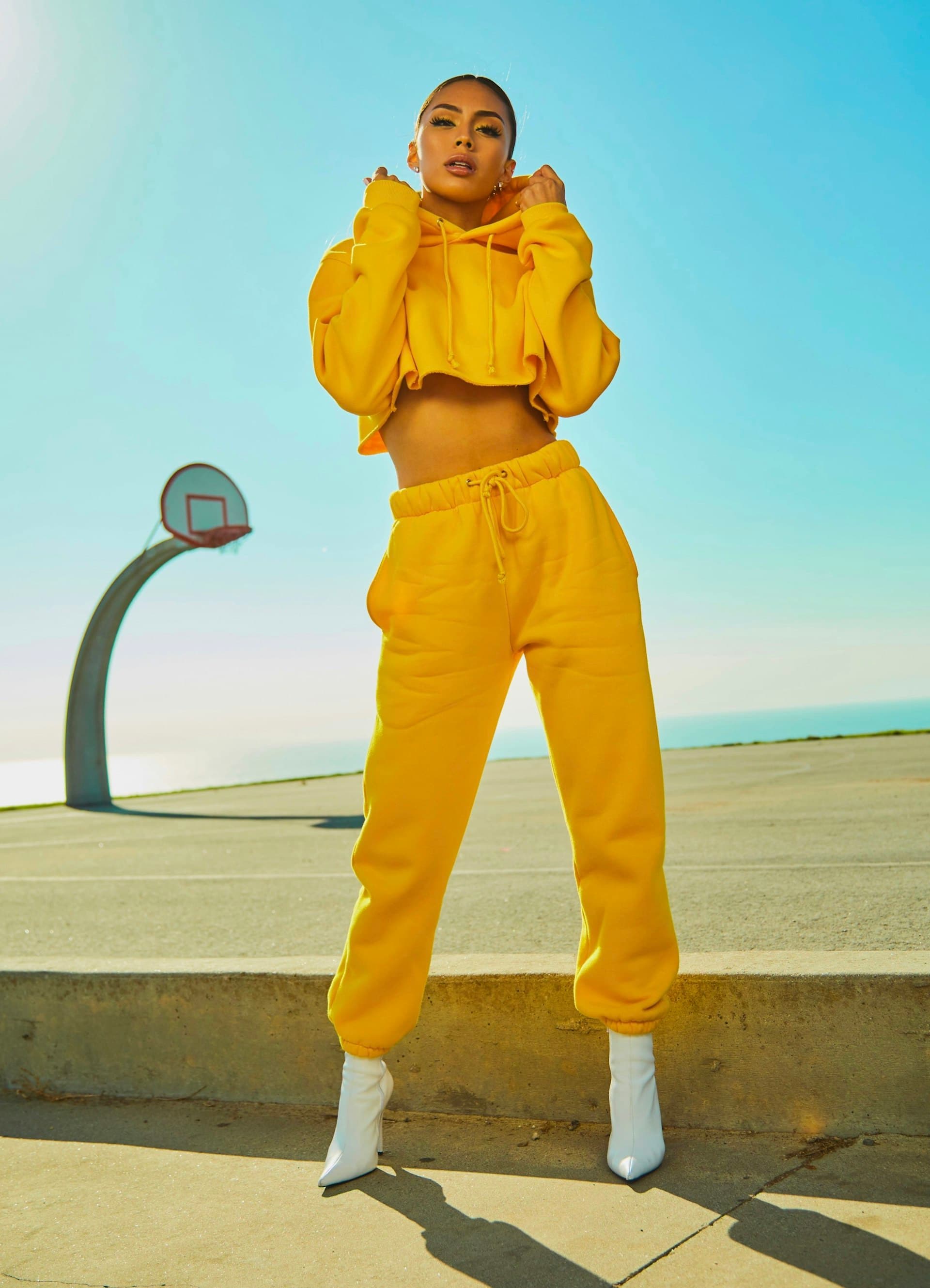 Model in a yellow tracksuit on an outdoor court